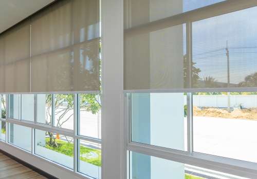 Roll Blinds on the windows, the sun does not penetrate the house. Window in the Interior Roller Blinds. Beautiful Blinds on the Window, the Sun and Heat Protection, the Perfect Windows Interior Decor